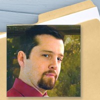 File folder with a photo of an unsmiling man with dark hair, mustache, and goatee and a label reading 'Witness Canvass - Friends'