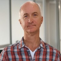 Balding man with a wryly serious expression