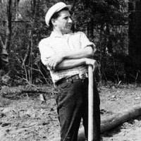 Old photo of a man in a flat cap with sleeves rolled up