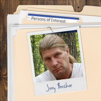 Photo of a Rough-looking man with long hair pulled back, clipped to a manila folder