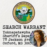 Seal of Yoknapatawpha County with the label 'Search Warrant' with an inset of a woman with dark, curly, shoulder-length hair