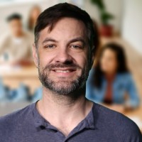 Smiling man with dark hair and facial hair