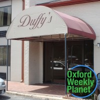 Duffy's Bar & Grill entrance with the Oxford Weekly Planet logo in the foreground