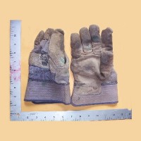 Sueded work gloves next to a measuring scale to show their size