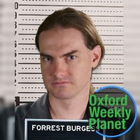 Mugshot of a brown-haired man with the Oxford Weekly Planet logo in the foreground