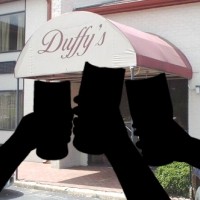 Silhouette of three hands holding beer glasses in front of a photo of Duffy's bar