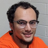 Man with short, dark, curly hair and glasses