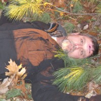 Man with a gunshot wound to the forehead lying dead in the woods