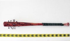 wood baseball bat with a wrapped hilt, spiked head, and reddish-brown stains