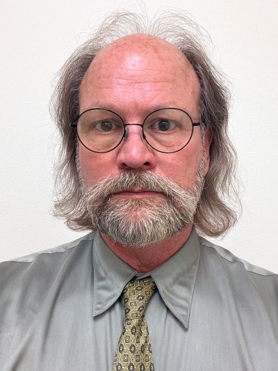 Balding man with glasses and gray facial hair