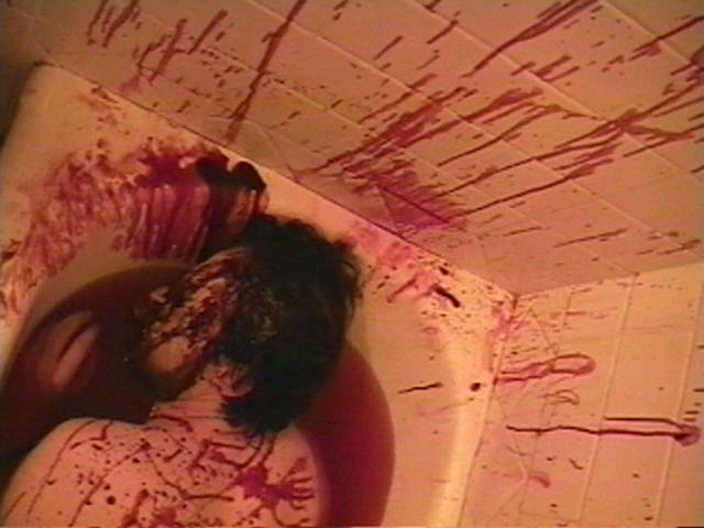 Bathtub filled with blood. Walls covered in spatter. Male victim floating in bloody water. View 2