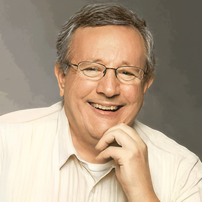 Grinning man with glasses and salt-and-pepper hair