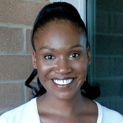 Smiling woman with dark hair in a ponytail