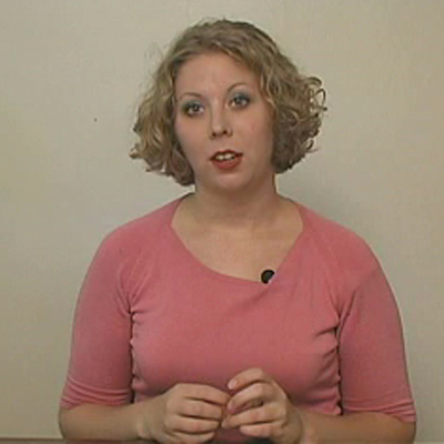 Woman with short blonde hair wearing a medium-pink shirt