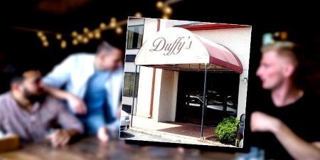 People chatting at a table in a bar with a photo of the Duffy's Bar & Grill entrance in the foreground