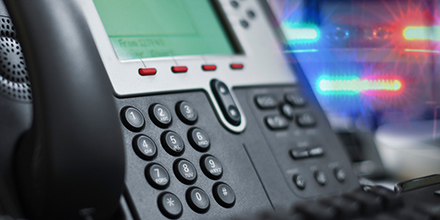 Business landline phone with police lights in the background