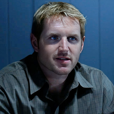 Squinting man with reddish-brown hair and mustache