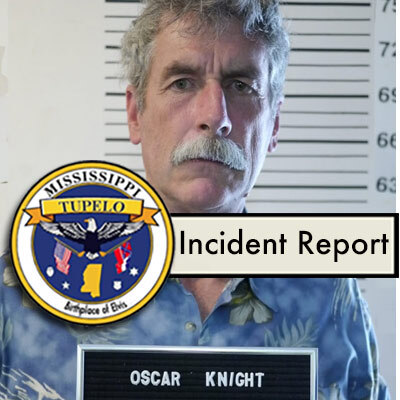 Police mugshot showing a man with bushy gray hair and mustache with the seal of Tupelo MS in the foreground