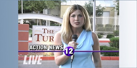 Blonde female reporter in front of an apartment complex entrance