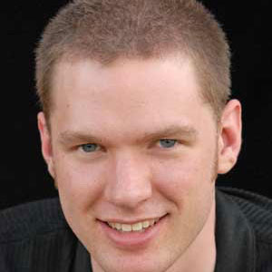 Smiling young man with close-cropped light brown hair