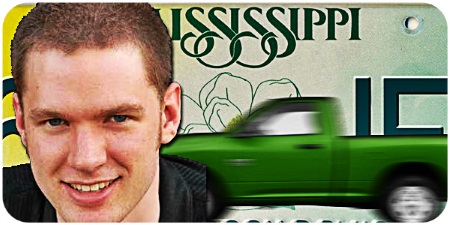 Smiling young man with close-cropped light brown hair with a green pickup and a Mississippi license plate in the background