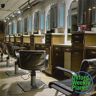 Client chairs in a hair salon with the Oxford Weekly Planet logo in the foreground