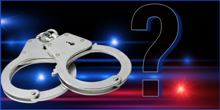 Handcuffs and a question mark with police lights in the background