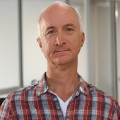 Balding man with a wryly serious expression