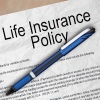 Photo of a portion of a life insurance document with a blue pen laid across it
