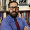 Man with dark hair, glasses and a salt-and-pepper goatee