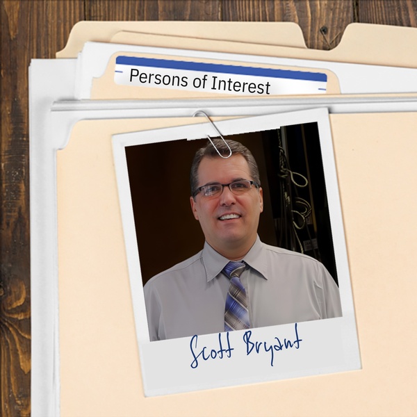 Manila folder with a photo of a smiling, clean cut man with glasses clipped to it