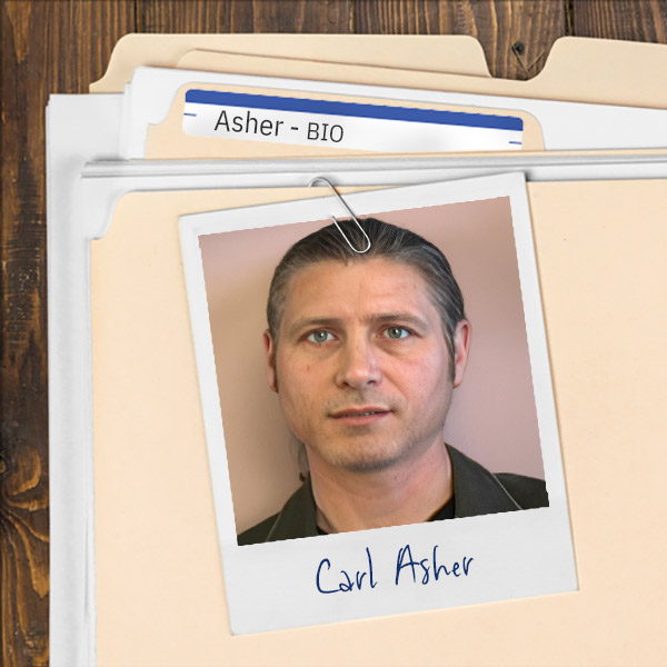 A file folder with a photo of a serious man with long dark hair pulled back in a ponytail.