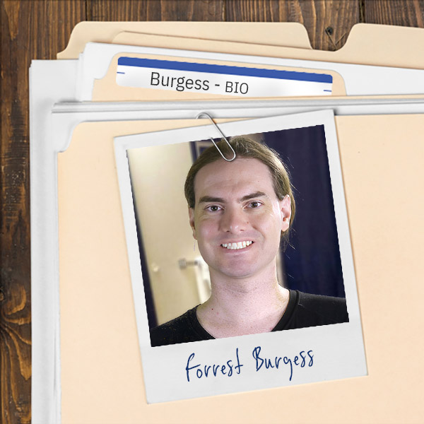 We see a file folder on a desk. Clipped to the folder is a picture of a smiling man with brown hair