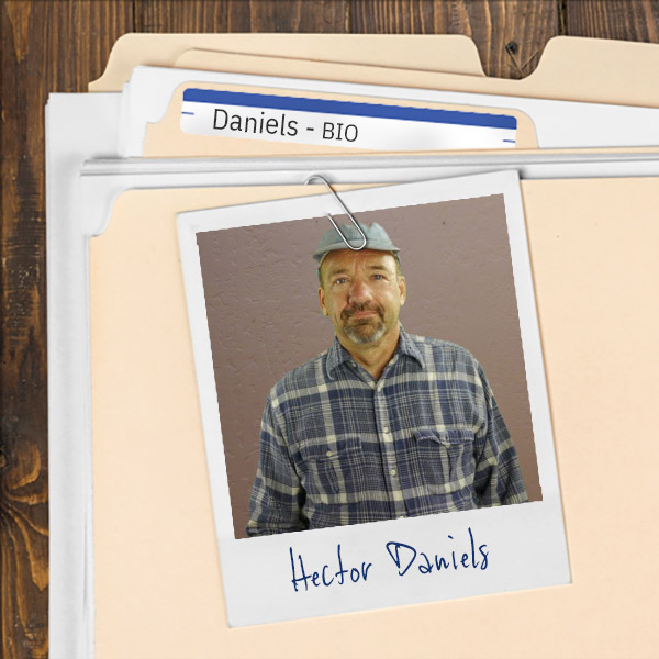 A file folder with a photo of a man in a gray cap with a salt and pepper mustache and goatee.