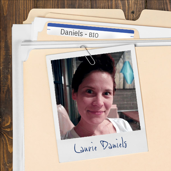 We see a file folder on a desk. Clipped to the folder is a picture of a smiling woman with dark hair