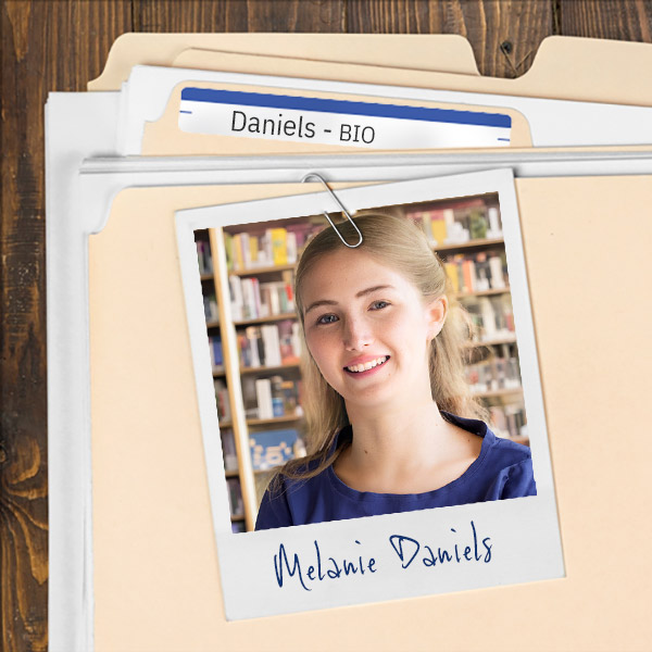 We see a file folder on a desk. Clipped to the folder is a picture of a smiling young woman with long, light brown hair