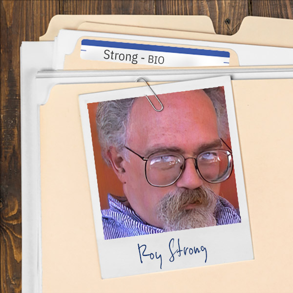 We see a file folder on a desk. Clipped to the folder is a picture of a man with glasses and gray hair and goatee