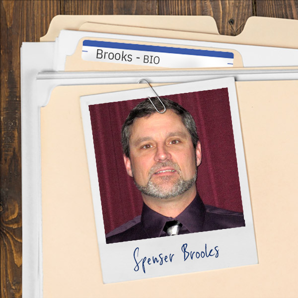 A file folder with a photo of a Man with short dark hair and salt and pepper beard and mustache.