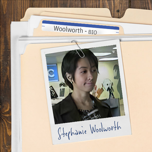 We see a file folder on a desk. Clipped to the folder is a picture of a young woman with short dark hair.