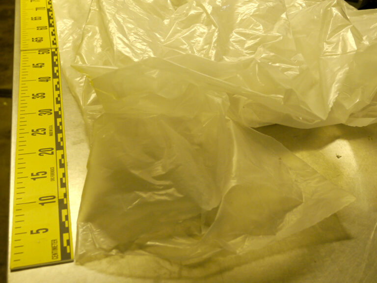 A picture of a tarp near a measuring stick.