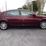A picture of a dark red colored car with 4 doors