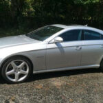A silver-colored sports car with 4 doors