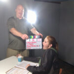 a picture of a man holding a clapboard near a woman.