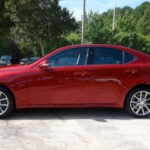 A picture of a red colored car with 4 doors