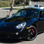 A black Porsche sports car with 2 doors