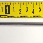 A picture of an arrow taken near a measuring ruler.