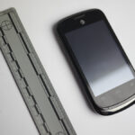 A picture of a burner phone taken near a measuring ruler