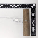 a picture of a garrote handle taken near a 90-degree measuring ruler.