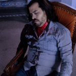 A picture of an unconscious man with blood streaming from his neck.