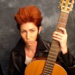 a picture of a person with a guitar and a dark background